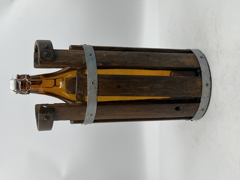 Eldre Ølflaske fra Eriksbergs Bryggeri, holdt i et trestativ med metallbånd