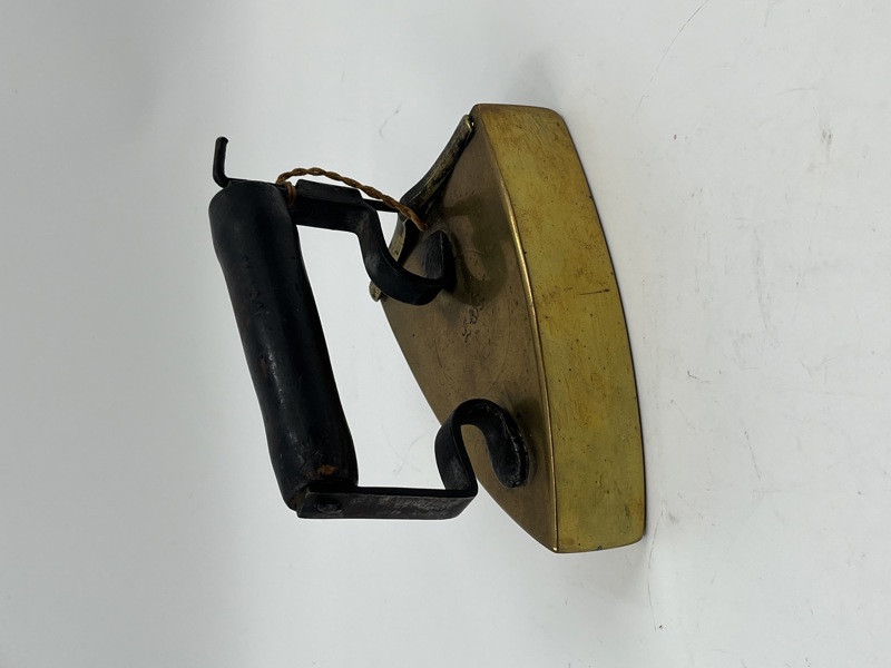 Gammel strykejern i messing med trehåndtak.