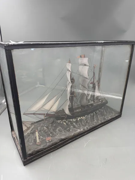 Detaljert modell av et historisk seilskip plassert i en glassmonter